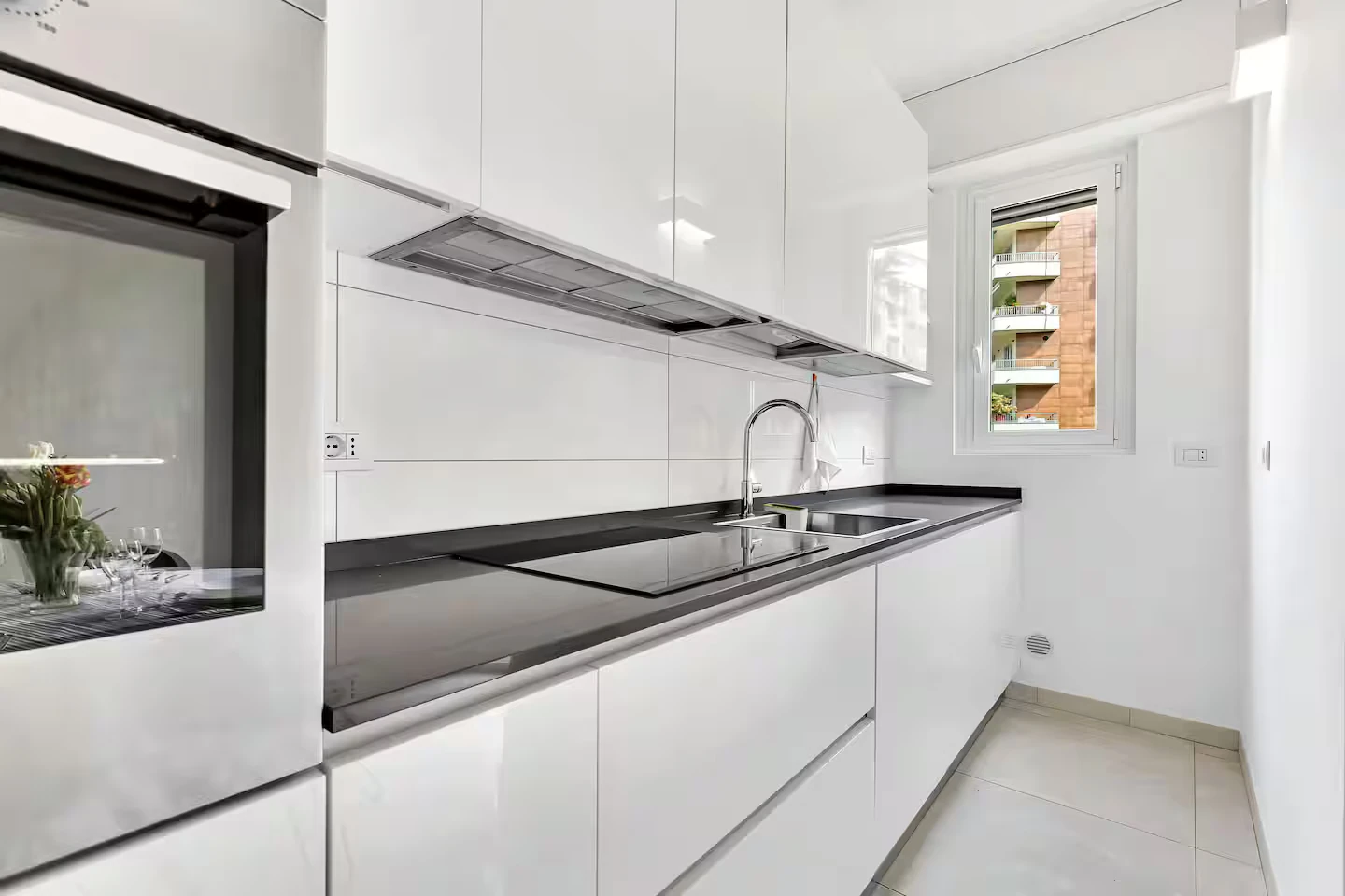 Cucina bianca con forno, piano cottura e lavello