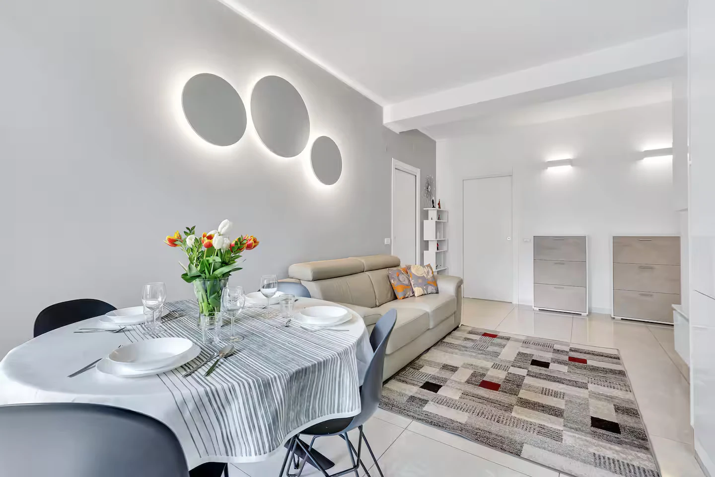 Tavolo da pranzo apparecchiato e divano nella zona giorno